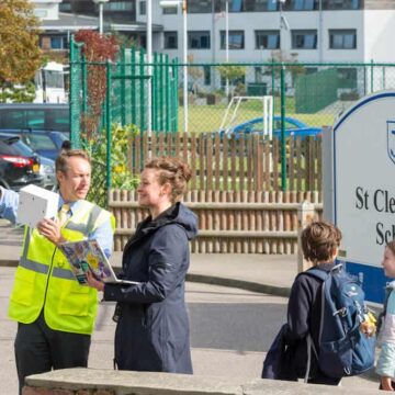 Government environmental health worker and Digital Jersey installing AirSensa environmental air sensor outside of St Clements school in Jersey