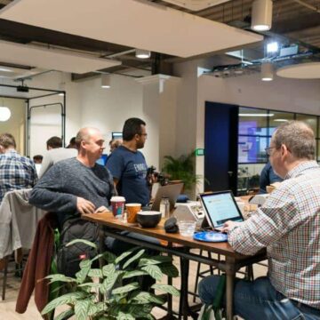 People working on laptops at high top tables in DJ Hub