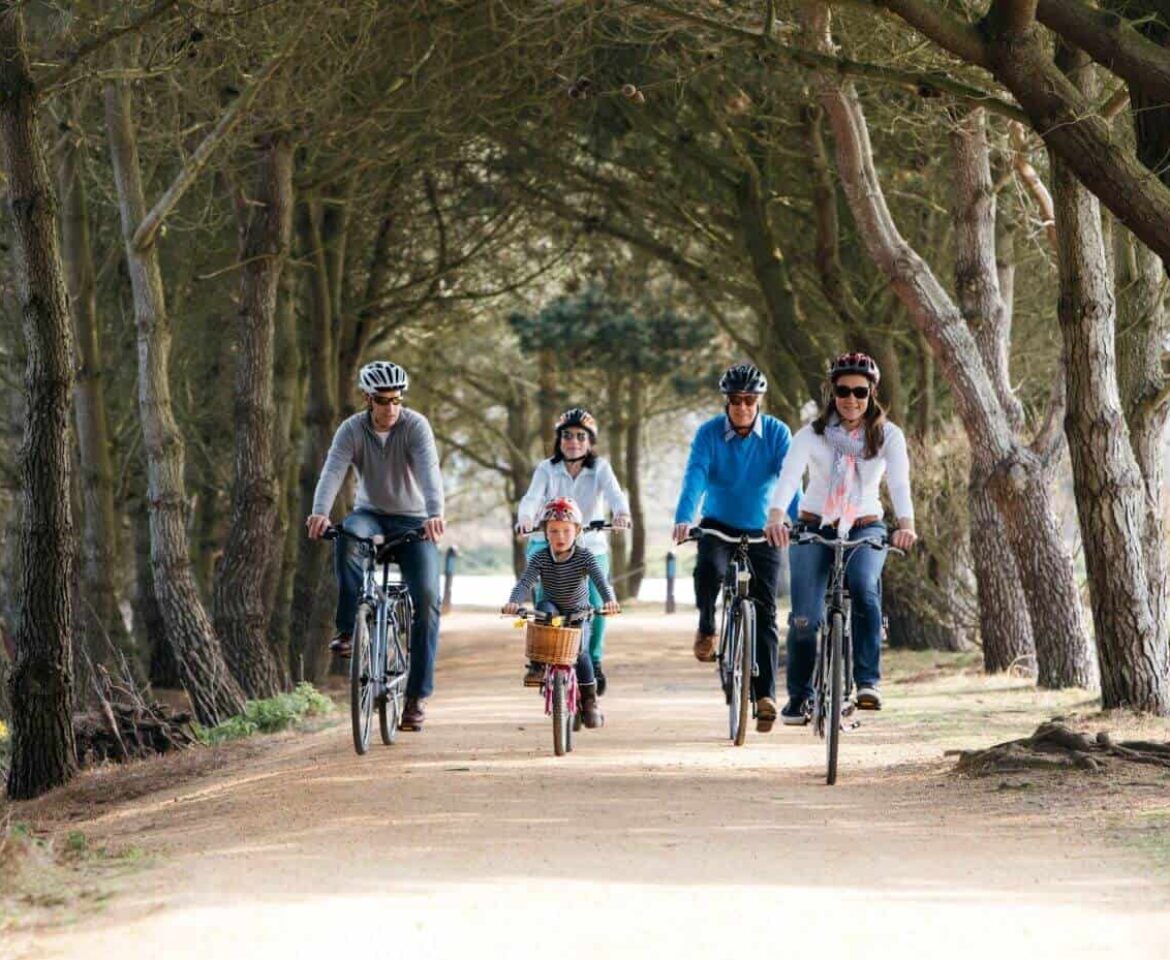 Family cycling on tree lined cycle track