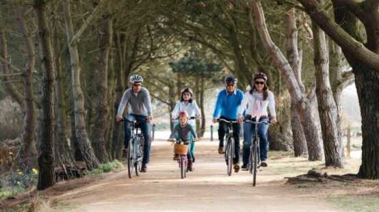 Family cycling on tree lined cycle track