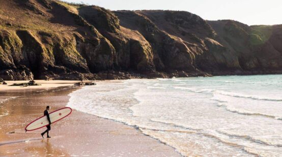 Surfer walking towards the water