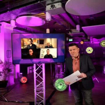 Gary Burgess hosting awards in front of TV