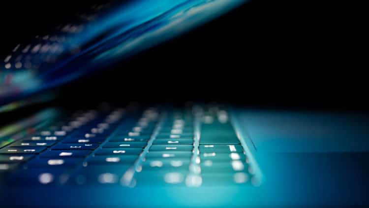 up close view of a half-closed laptop in the dark