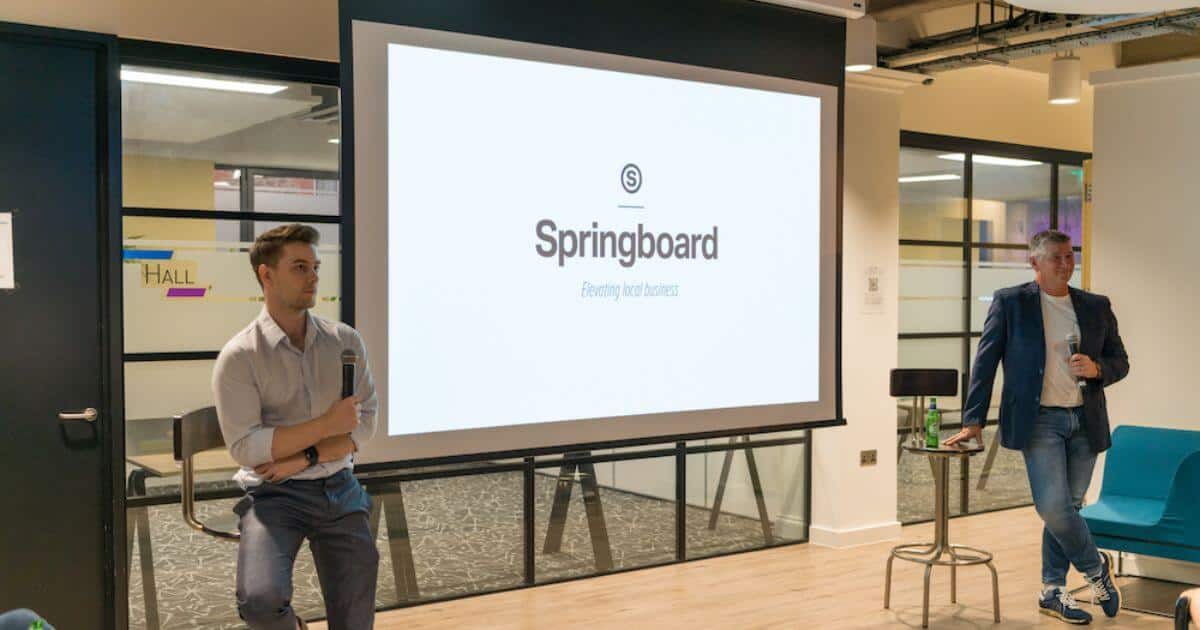 Two presenters either side of a powerpoint screen at a springboard event in the Digital Jersey Hub