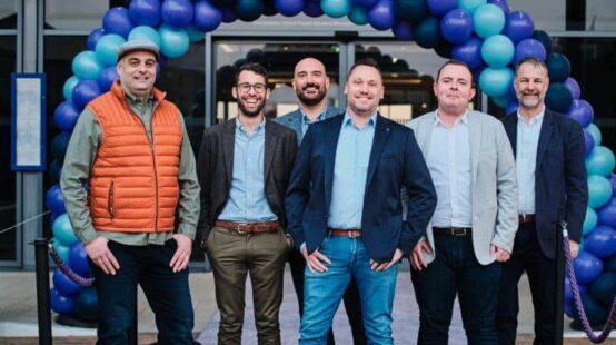 group of men posing on purple carpet