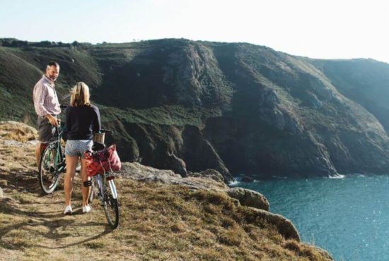 People on bikes overlooking cliff path and sea
