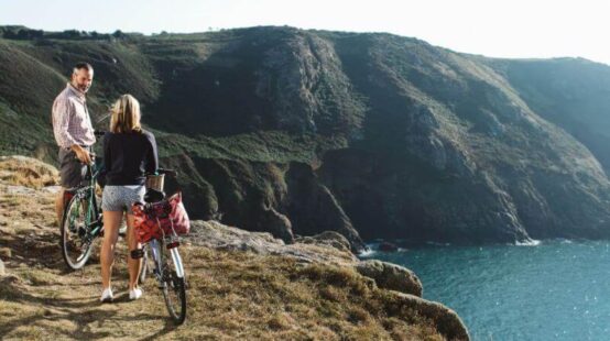 People on bikes overlooking cliff path and sea