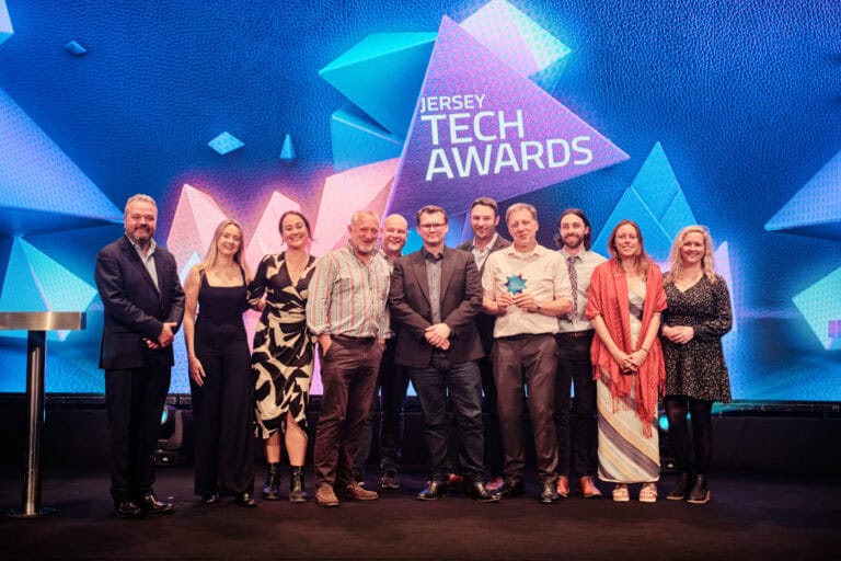 Innovation Award Winner, Government of Jersey Marine Resources, stood on stage with award and host Hal Cruttenden