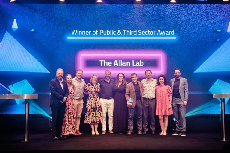 Public and Third Sector Award Winner, The Alan Lab, stood on stage with award and host Hal Cruttenden