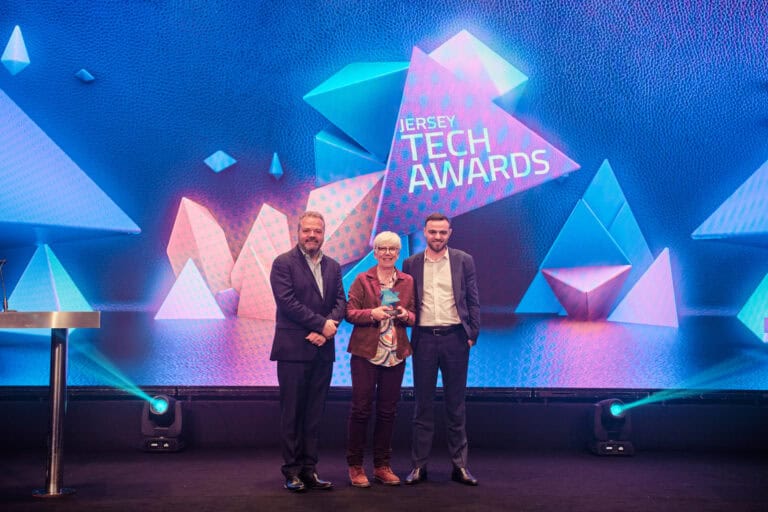 Teacher Award Winner, Ruth Lea, stood on stage with award and host Hal Cruttenden