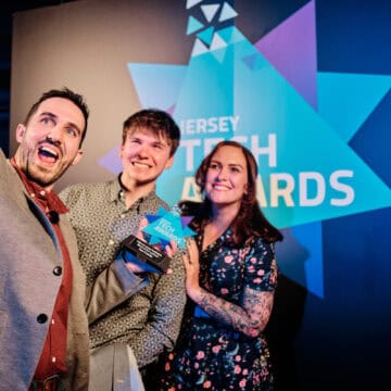 Three people posing for photo with award
