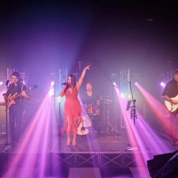 performer on stage with lighting in background