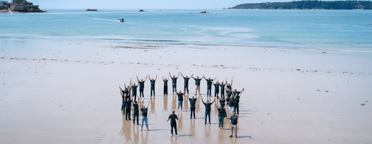 The Quantios team form a Q shape on the beach