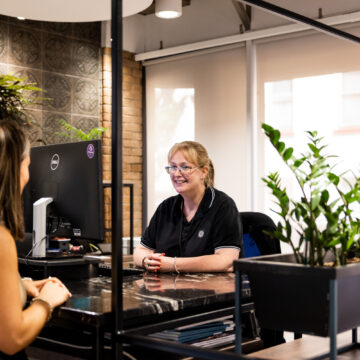 two women sat across each other at a desk